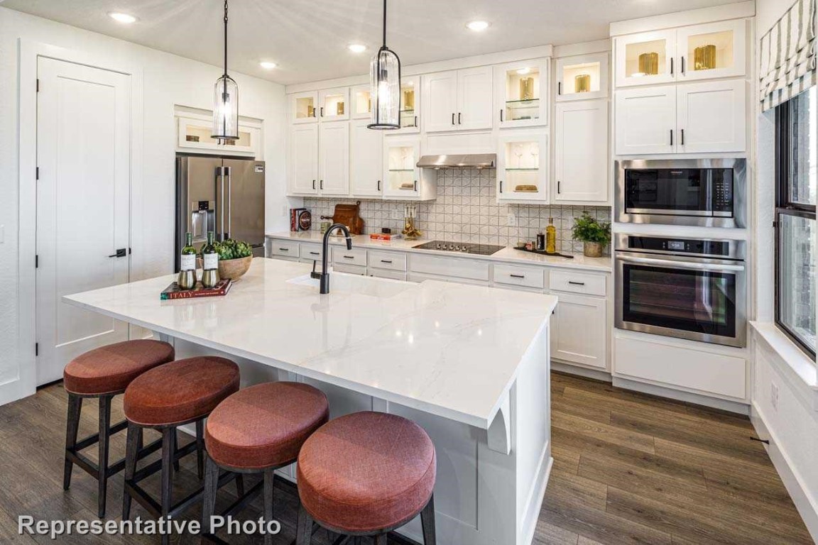 a kitchen with stainless steel appliances a dining table chairs stove and sink