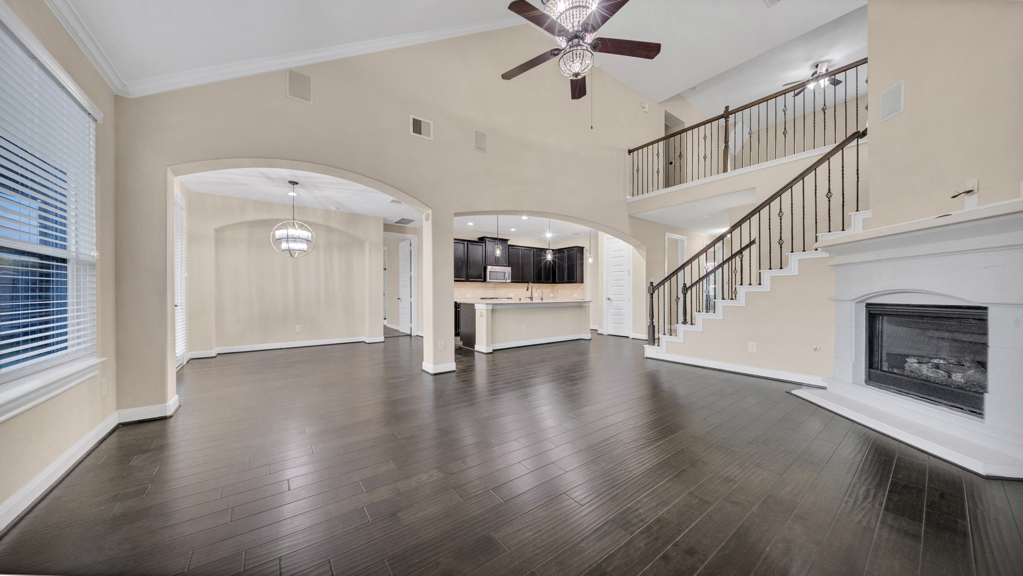 18118 Berry Garden Lane Spring, TX 77379 - Photo 9 of 45 Open and airy two-story family room with rich wood flooring, crown molding, and a classic corner fireplace.