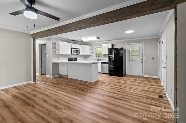 a view of a kitchen with wooden floor and a refrigerator