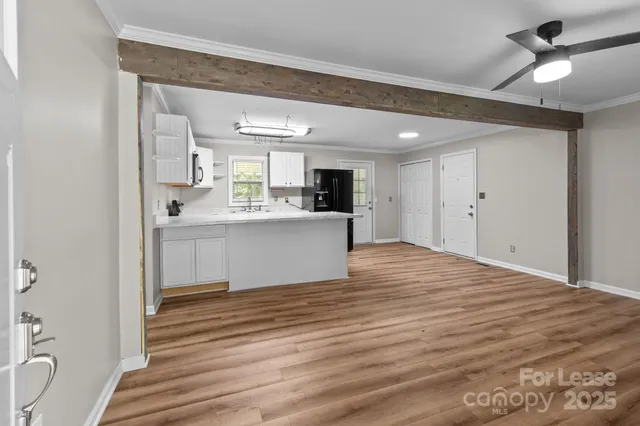 a view of a kitchen with wooden floor and a sink