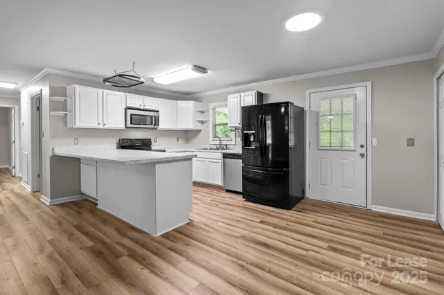 a kitchen with stainless steel appliances a refrigerator sink and microwave