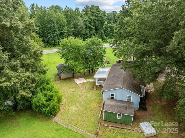 an aerial view of a house with swimming pool and garden view