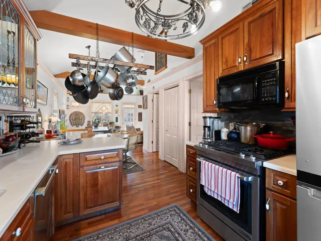 a kitchen with stainless steel appliances granite countertop a stove a sink dishwasher and cabinets with wooden floor