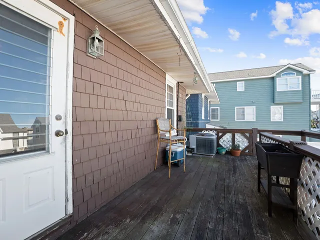 a view of a patio with table and chairs with wooden floor and fence