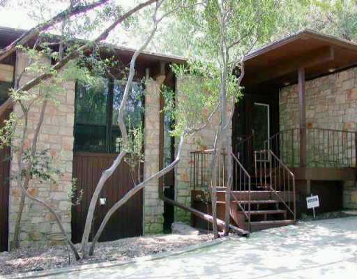 a view of a house with a door and a wooden bench