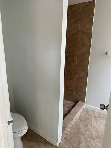 a bathroom with a granite countertop shower and a toilet