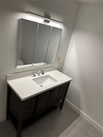 a bathroom with a sink vanity and a mirror