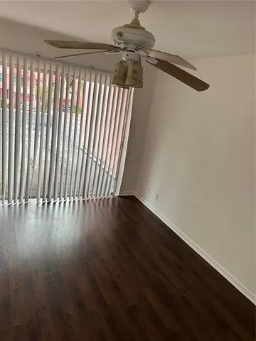 en empty room with wooden floor and windows