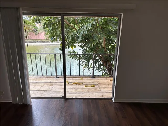 a view of a small space with wooden floor and a window