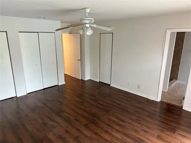 an empty room with wooden floor and closet area