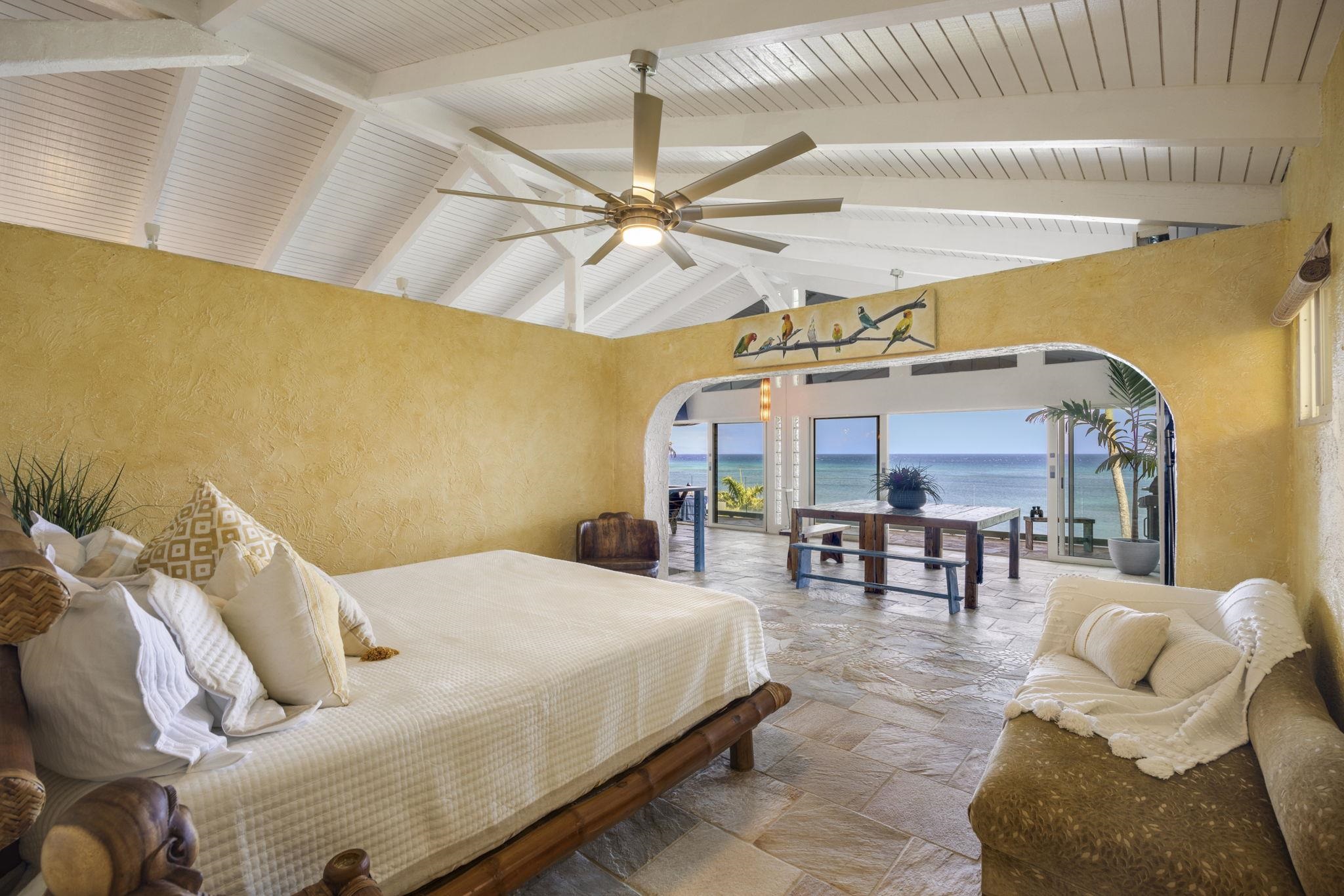 5171 Lower Honoapiilani Road Lahaina, HI 96761 - Photo 19 of 48 a spacious bedroom with a bed a couch and a chandelier