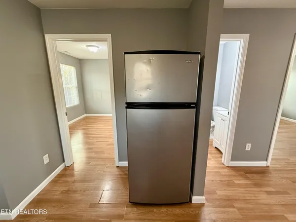 a view of a living room with wooden floor and a hallway