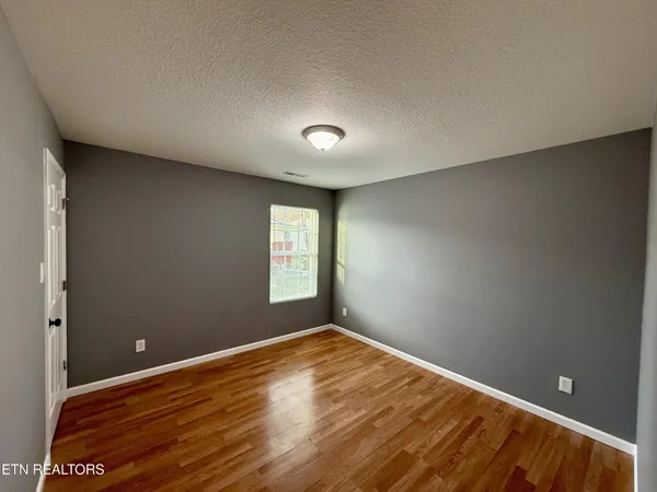a view of room with window and wooden floor