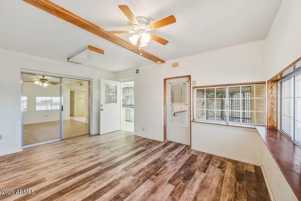 a view of a livingroom with wooden floor and a ceiling fan