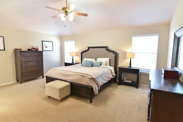a bedroom with a bed and dresser with mirror