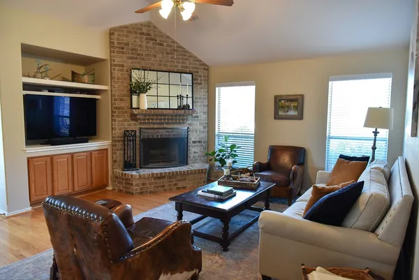 a living room with furniture a flat screen tv and a fireplace