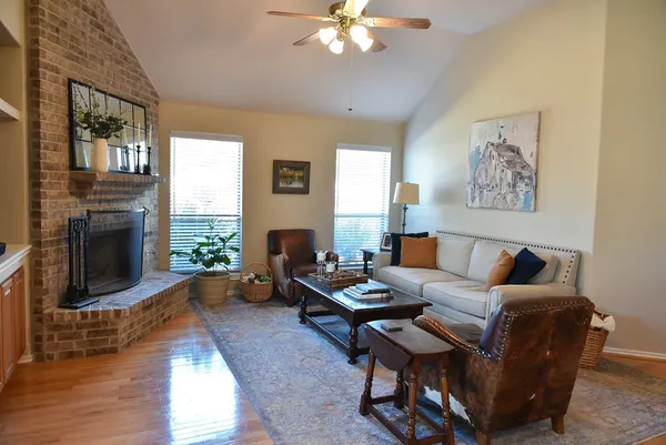 a living room with furniture a fireplace and a large window