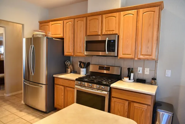 a kitchen with stainless steel appliances granite countertop a refrigerator a stove a sink and dishwasher