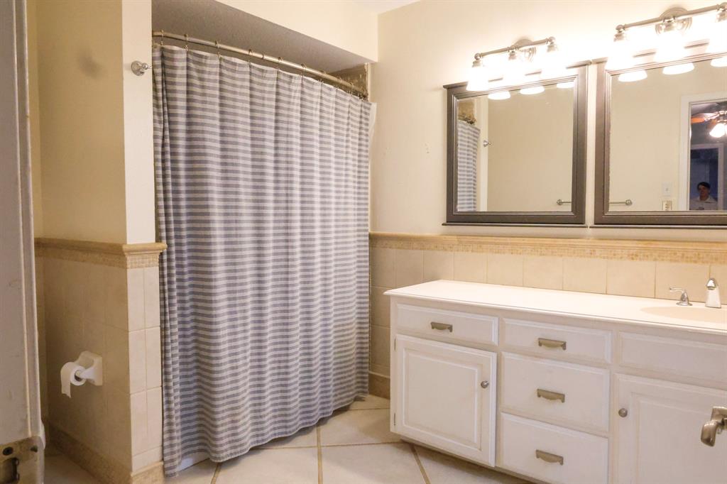 740 Peavy Road Dallas, TX 75218 - Photo 11 of 19 a bathroom with a sink and a mirror