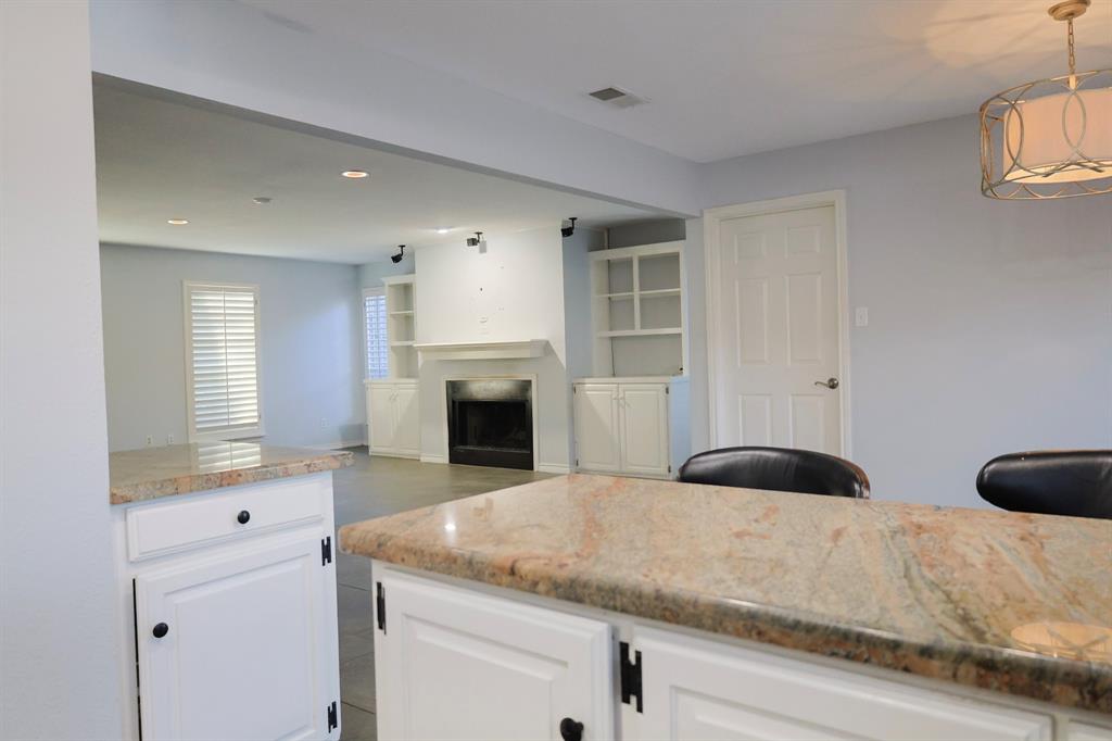 740 Peavy Road Dallas, TX 75218 - Photo 7 of 19 a kitchen with granite countertop white cabinets and a fireplace
