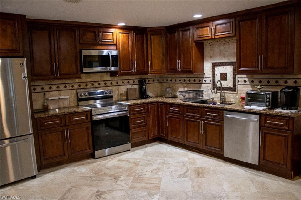 17565 Butler Road Fort Myers, FL 33967 - Photo 6 of 12 a kitchen with stainless steel appliances granite countertop a stove microwave and sink