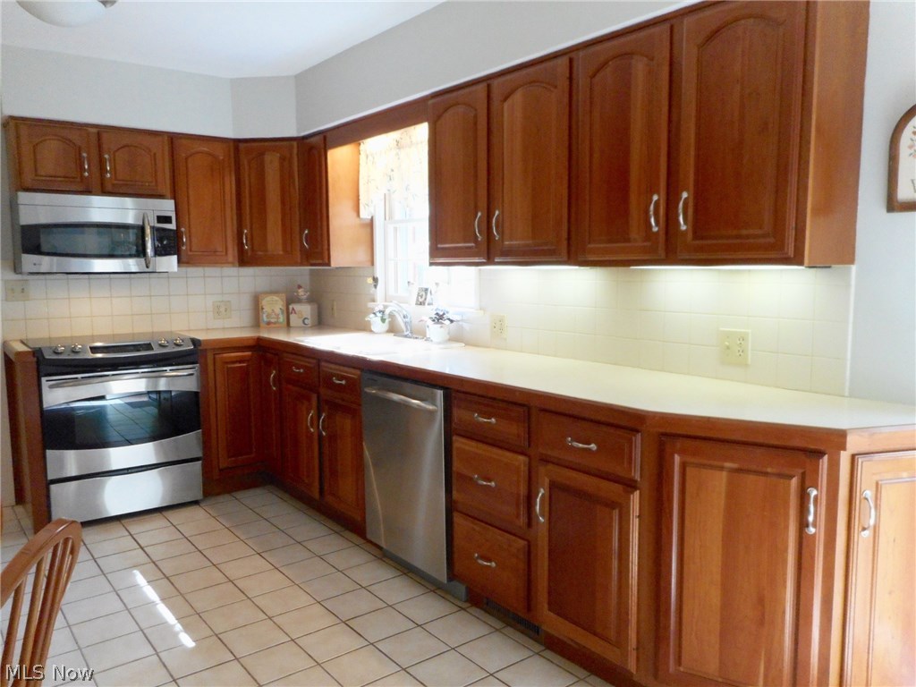856 Old Spring Road Akron, OH 44321 - Photo 5 of 30 The kitchen has quality cherry cabinets, and neutral counter tops and tiled back splash, with ceramic tile floors.