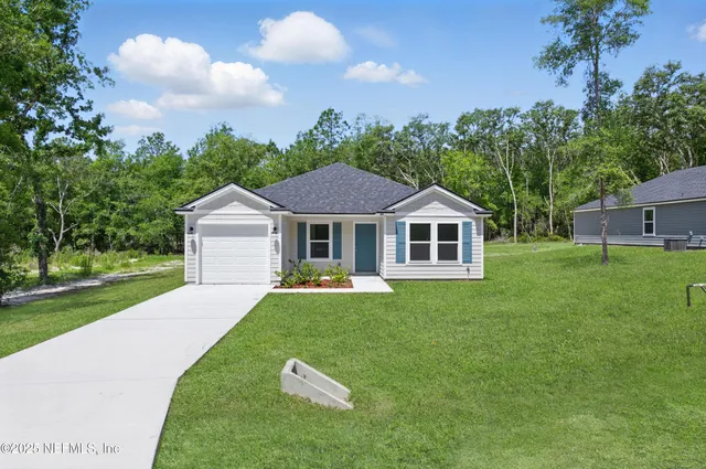 a aerial view of a house with yard and green space