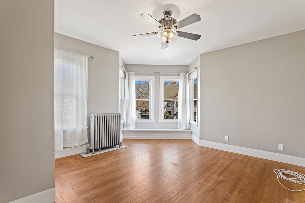 175 High Street Taunton, MA 02780 - Photo 13 of 39 a view of an empty room with a window and wooden floor