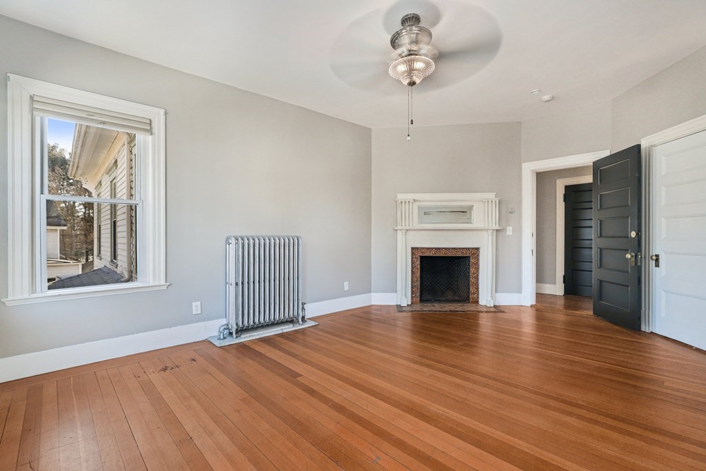 175 High Street Taunton, MA 02780 - Photo 19 of 39 a view of a livingroom with wooden floor and a fireplace