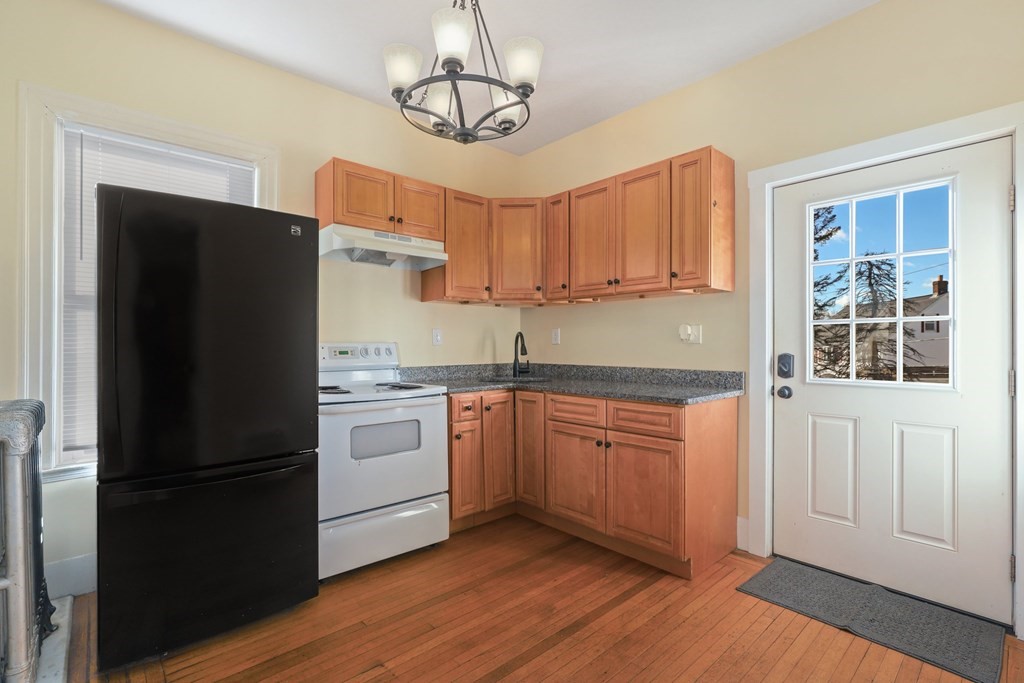 175 High Street Taunton, MA 02780 - Photo 23 of 39 a kitchen with stainless steel appliances granite countertop a refrigerator a sink dishwasher a stove and white countertops with wooden floor