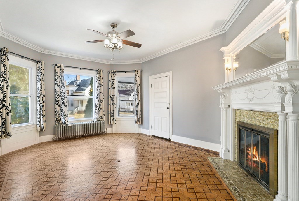 175 High Street Taunton, MA 02780 - Photo 4 of 39 a view of an empty room with a fireplace and a window