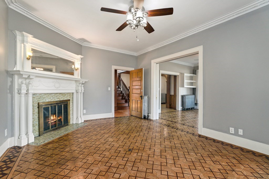 175 High Street Taunton, MA 02780 - Photo 5 of 39 a view of a livingroom with a fireplace a chandelier fan and windows