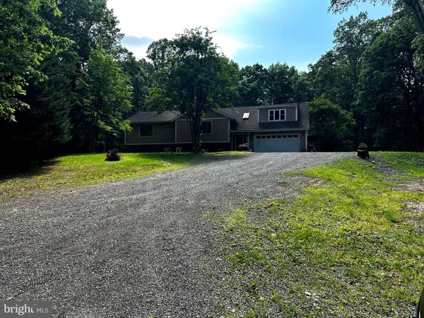 a front view of a house with a yard and trees