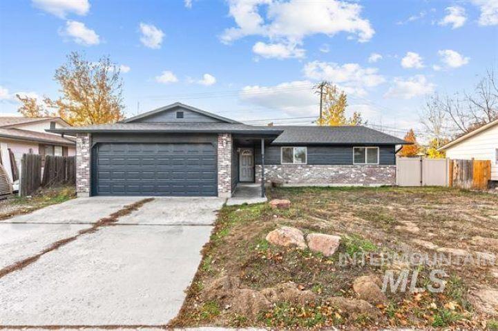 Ranch-style house featuring concrete driveway, a garage, and stone siding
