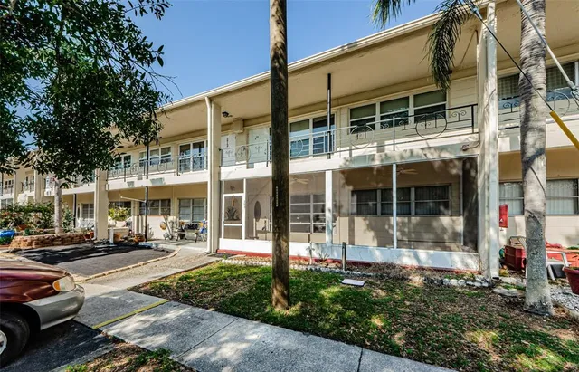 a view of a building with a cars park side of a road