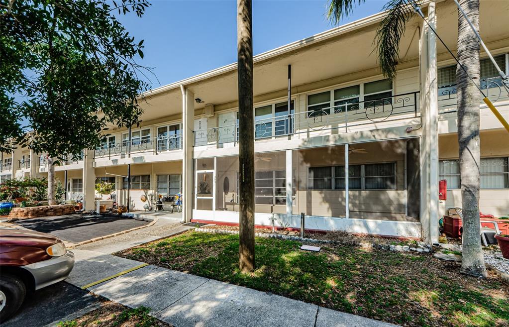 a view of a building with a cars park side of a road