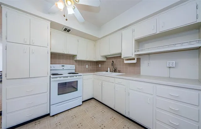a view of a kitchen with a refrigerator and a stove top oven