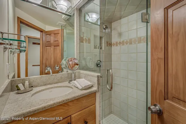 a bathroom with a granite countertop sink a toilet and shower