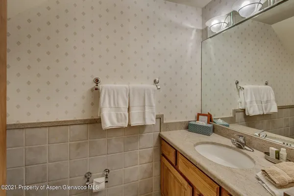 a bathroom with a granite countertop sink a mirror and a shower