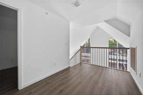 a view of a hallway with wooden floor and stairs
