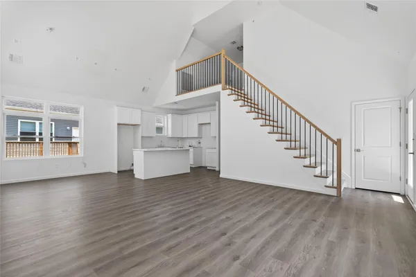 a view of a livingroom with wooden floor and stairs