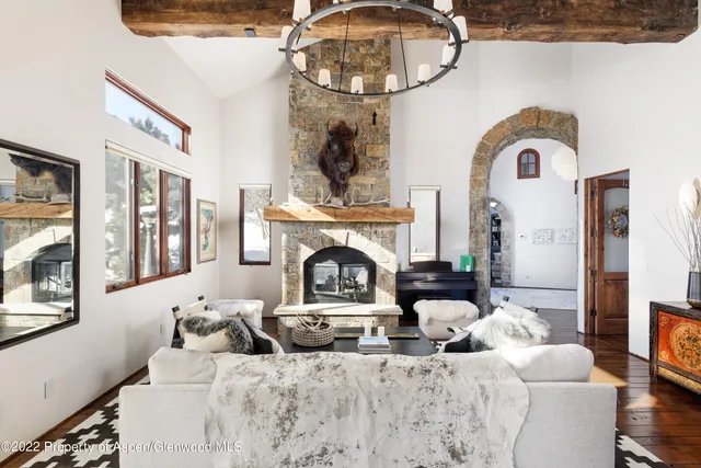 a living room with furniture a fireplace and a chandelier