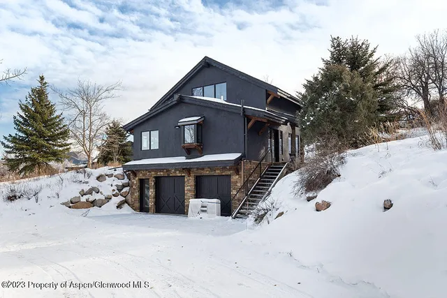 a front view of a house with a yard covered in snow