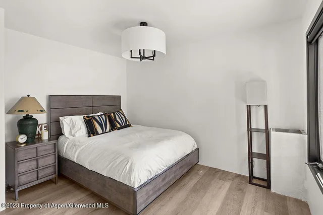 a bedroom with a bed and a large mirror on dresser