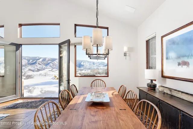 a view of a dining room with furniture a chandelier and wooden floor