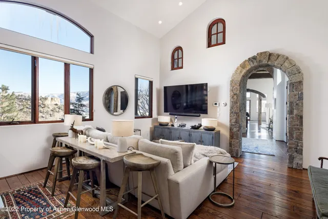 a living room with furniture a large window and a flat screen tv
