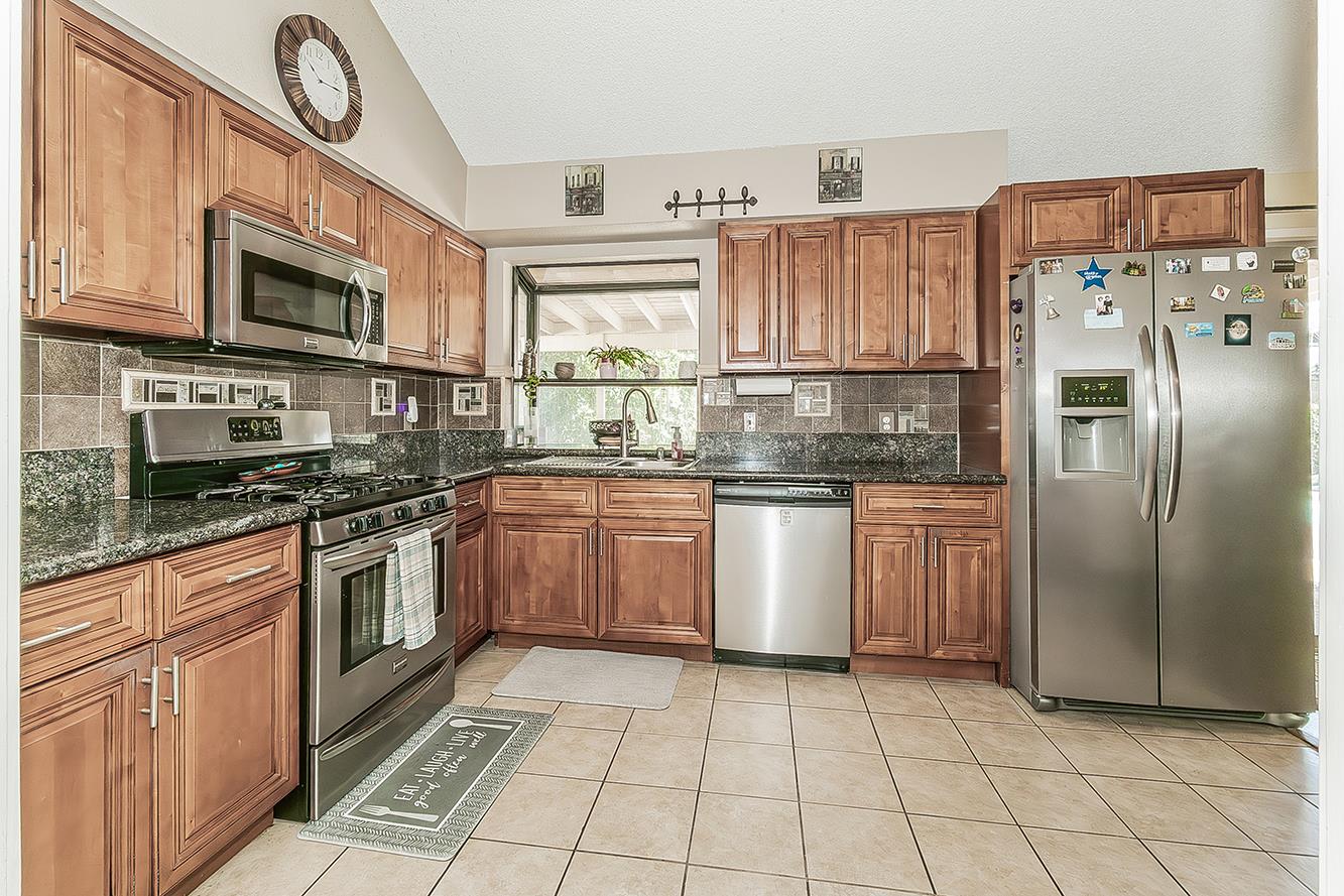 1908 East Niles Avenue Fresno, CA 93720 - Photo 8 of 30 a kitchen with stainless steel appliances granite countertop a refrigerator a stove a sink and a microwave