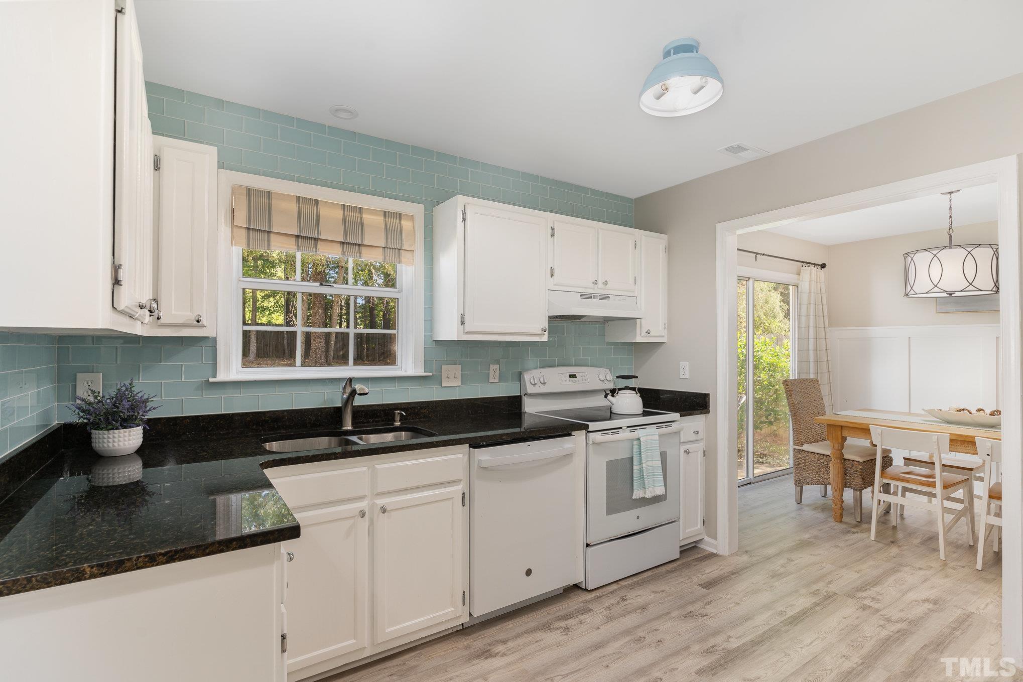 2014 Talloway Drive Cary, NC 27511 - Photo 5 of 18 a kitchen with stainless steel appliances granite countertop a stove a sink and white cabinets