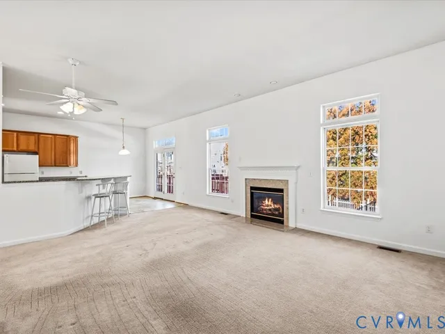 an empty room with windows and fireplace