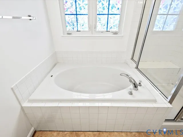 a bathroom with bathtub and window